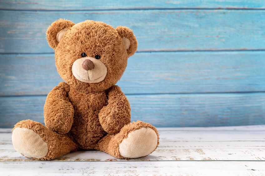 Cute teddy bear with copy space on blue color wood background.