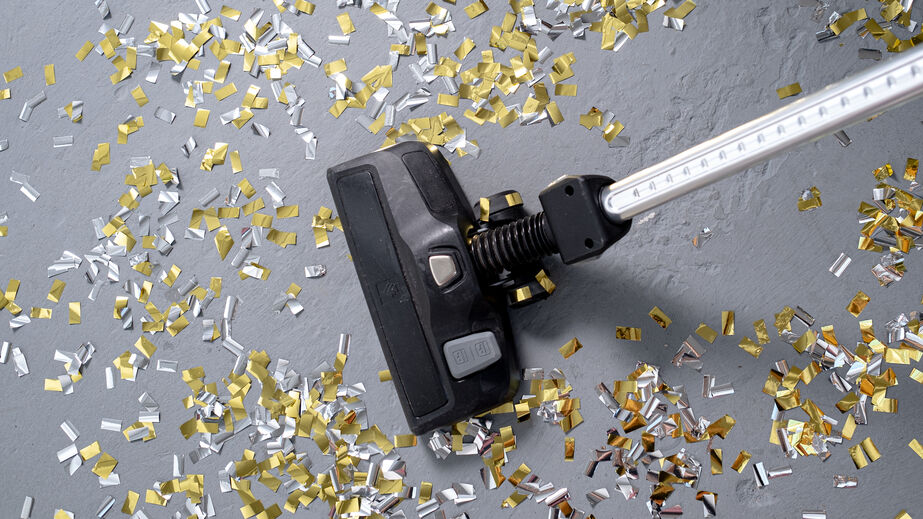 person vacuuming glitter from party