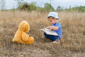 child reading to stuffed animal