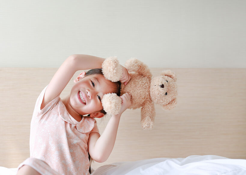 smiling girl playing with teddy bear
