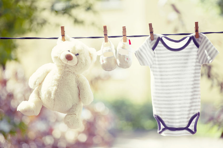 teddy bear on clotheline with baby clothes