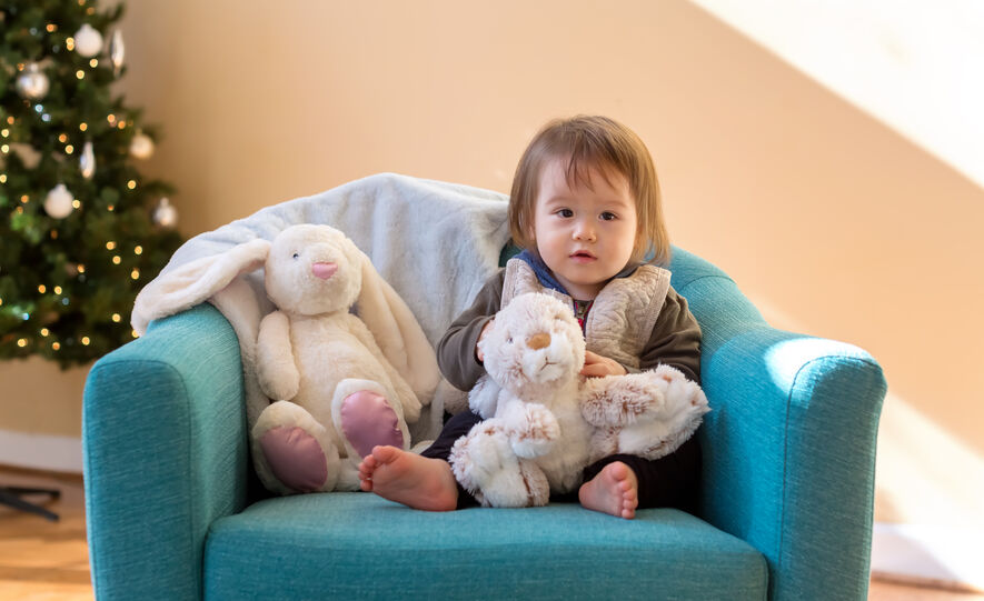 toddler sitting with stuffed animals