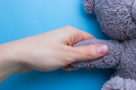 girl hands holding a teddy bear