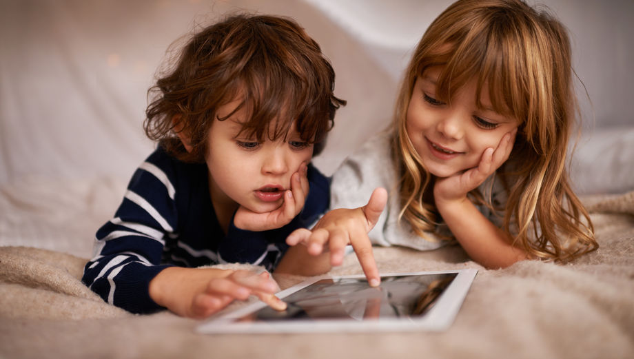 boy and girl playing on tablet