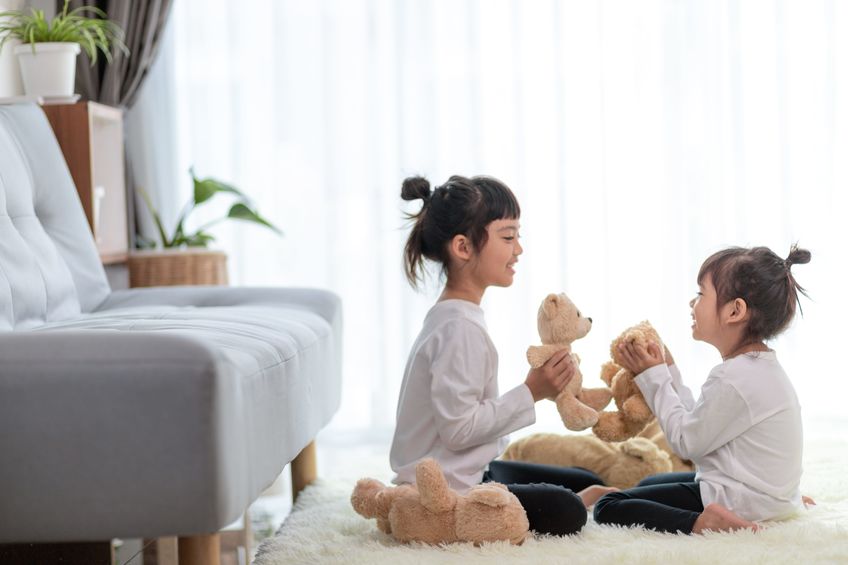 children playing with teddy bear at home