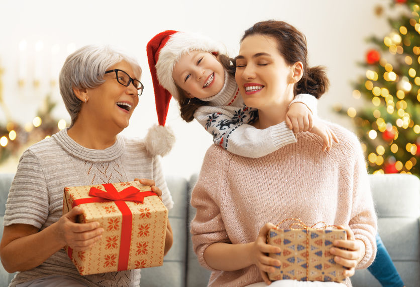 kid giving christmas gifts to mom and grandma