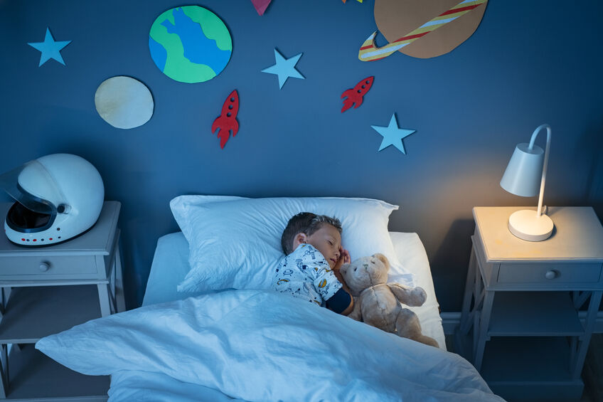 toddler sleeping in bed with stuffed animal