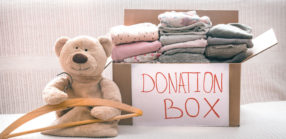 stuffed animal sitting next to donation box