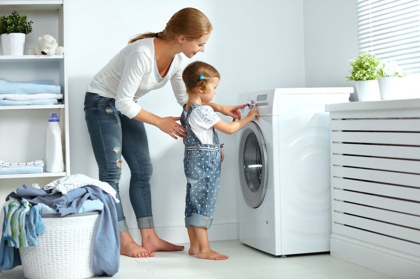 mother and child using washing machine