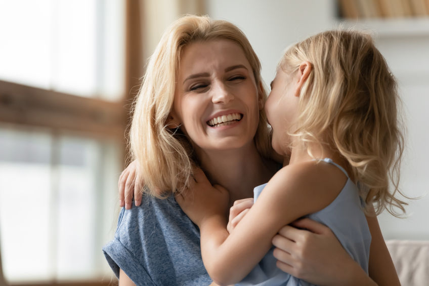 mother and daughter hugging one another