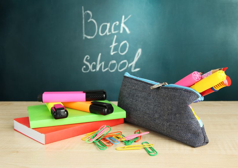 back to school - blackboard with pencil-box and school equipment on table