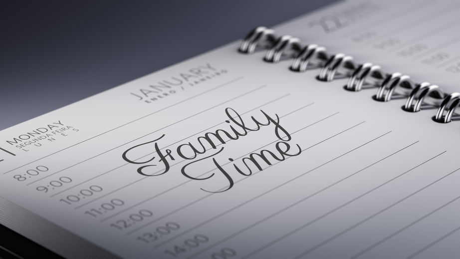 Closeup of a personal calendar setting an important date representing a time schedule. The words Family Time written on a white notebook to remind you an important appointment.