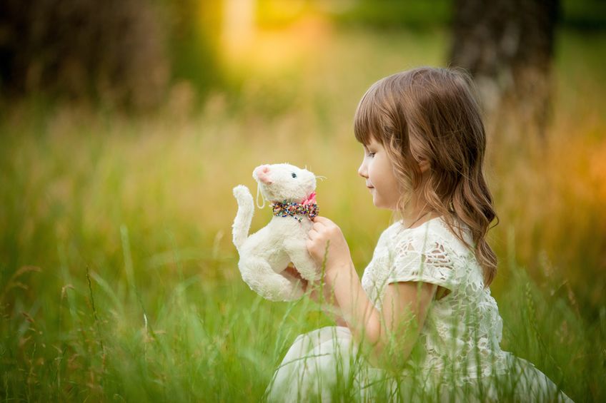 Little girl playing in the park with a toy